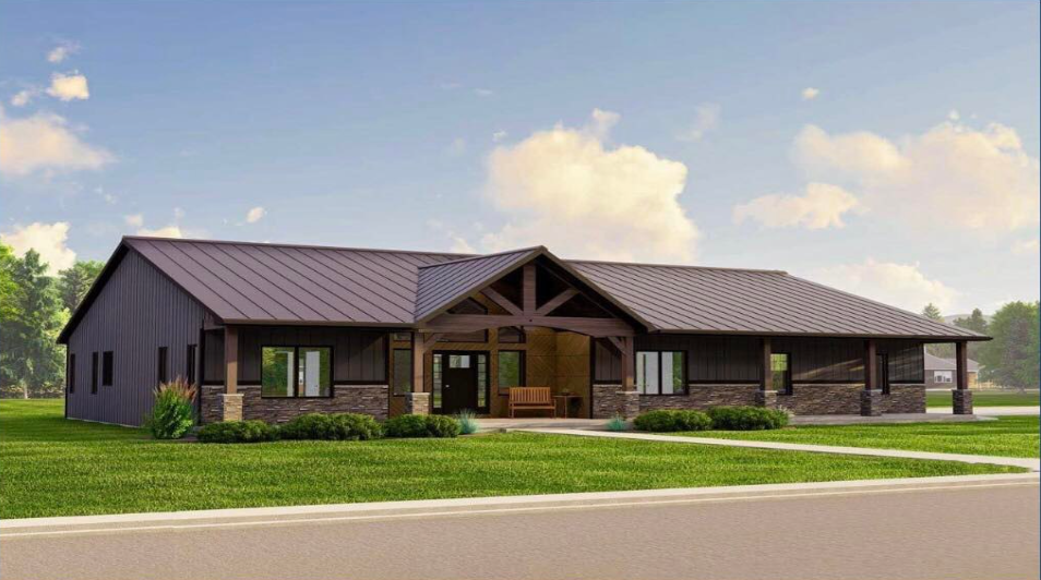 Ranch-style home with brown standing seam metal roof panels, stone accents, covered porch, and landscaped front lawn.